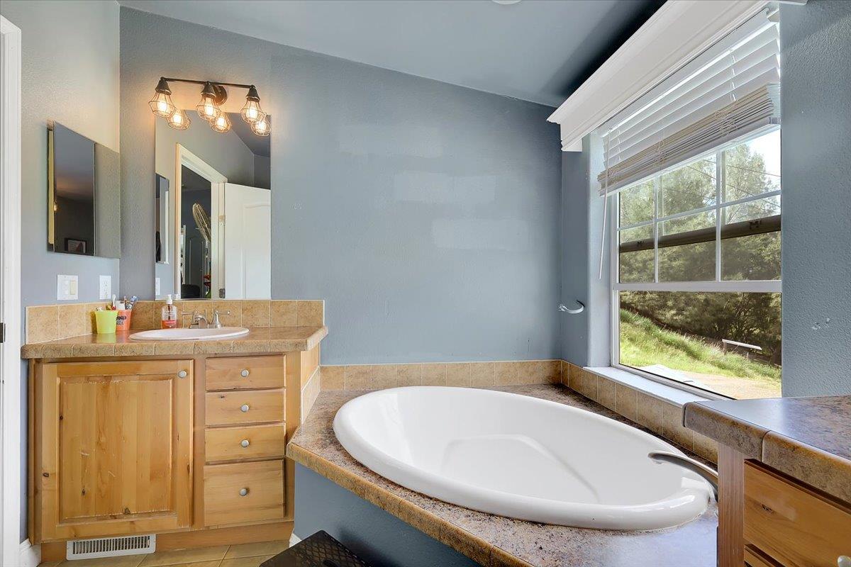 10268 Peoria Road Browns Valley, CA 95918 - Photo 34 of 57 a bathroom with a granite countertop sink mirror and a bathtub