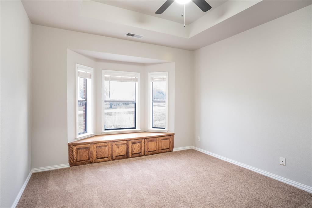 250 Timberleaf Drive Double Oak, TX 75077 - Photo 17 of 23 an empty room with a fireplace and large windows