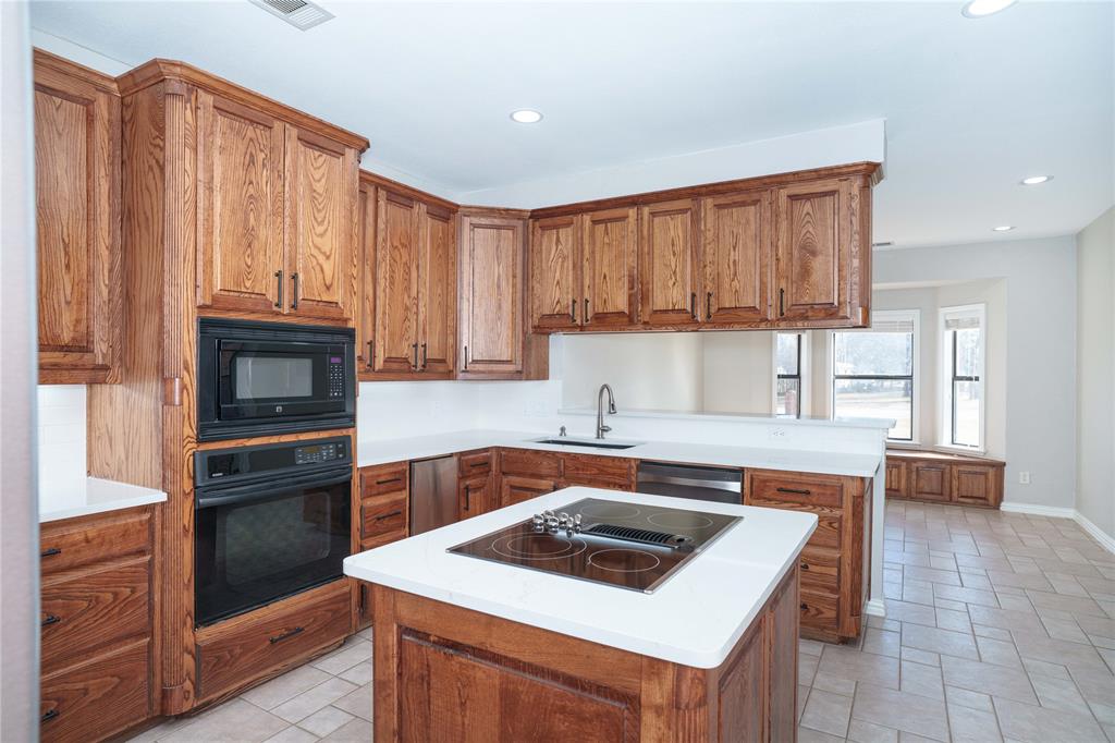 250 Timberleaf Drive Double Oak, TX 75077 - Photo 6 of 23 a kitchen with granite countertop a stove top oven and cabinets