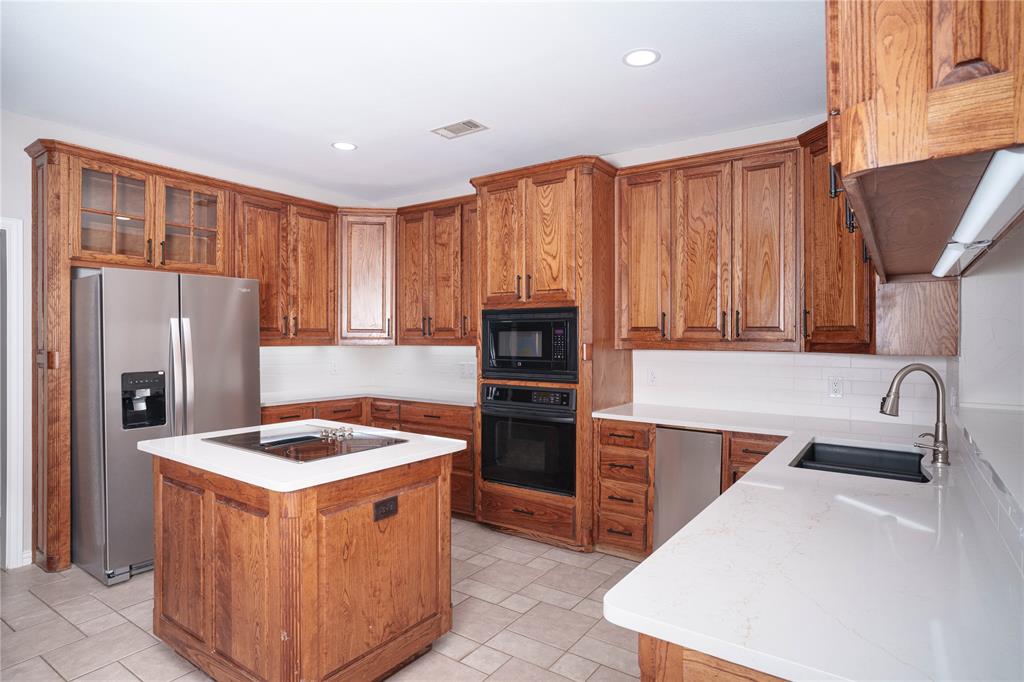 250 Timberleaf Drive Double Oak, TX 75077 - Photo 7 of 23 a kitchen with stainless steel appliances granite countertop a refrigerator stove and sink