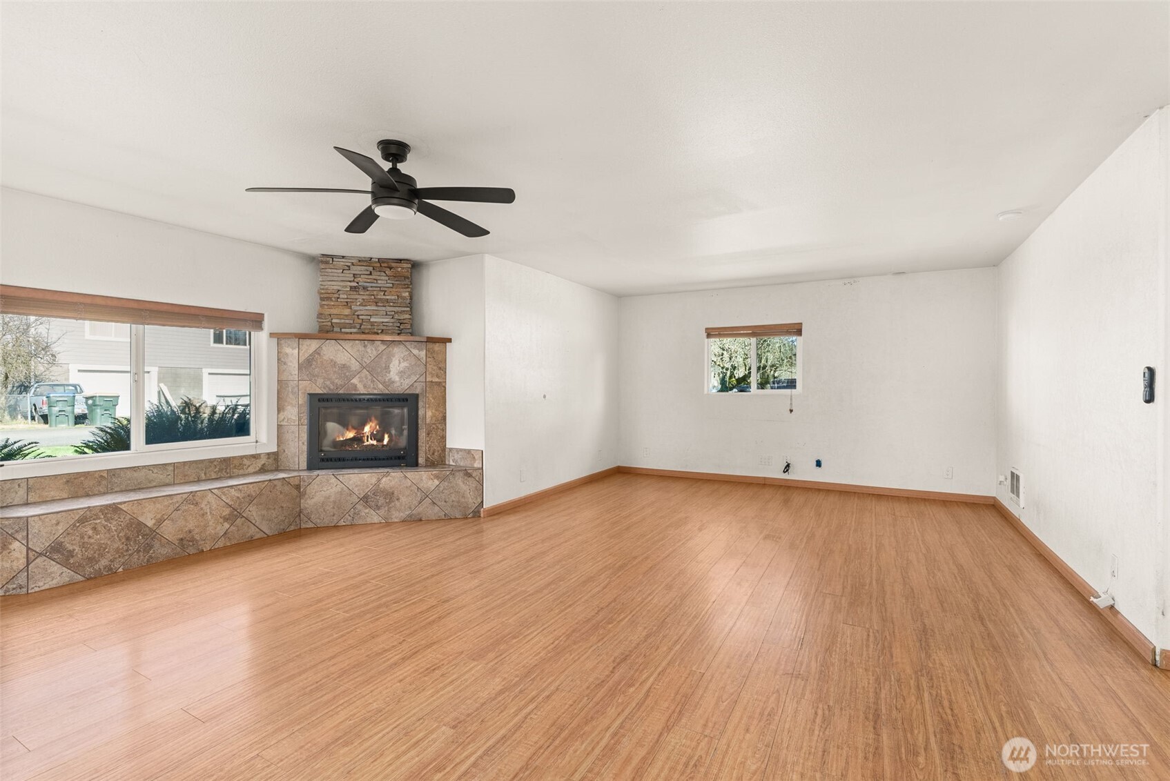 802 State Street Centralia, WA 98531 - Photo 4 of 40 an empty room with windows fireplace and wooden floor