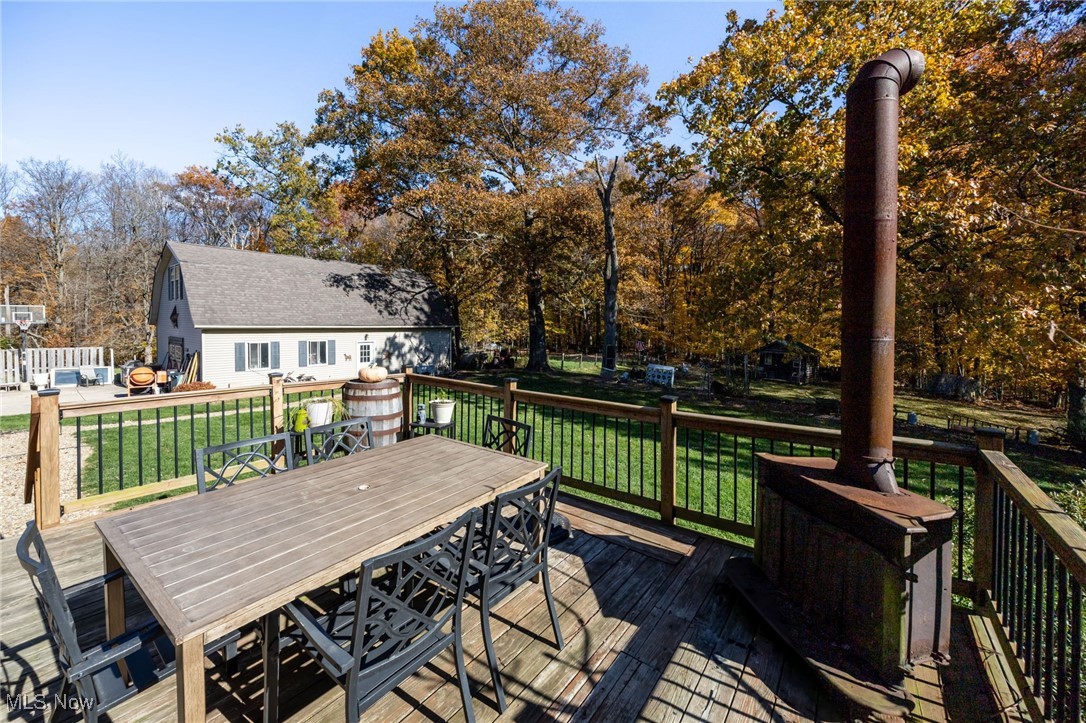 11827 Stratton Road West Salem, OH 44287 - Photo 10 of 47 Wooden deck with a yard, outdoor dining area, and view of scattered trees