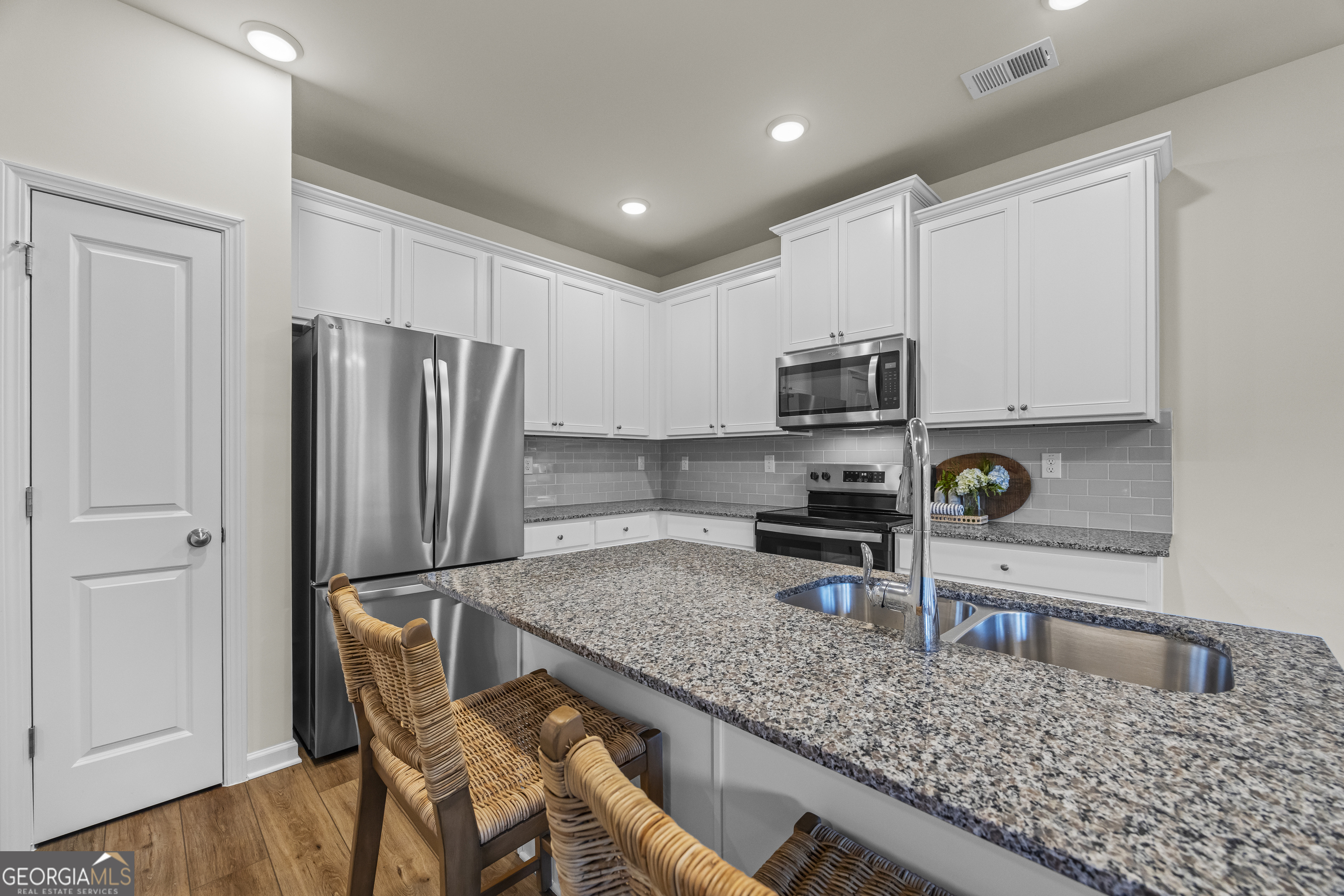 550 Buxton Road Hoschton, GA 30548 - Photo 12 of 57 a kitchen with refrigerator cabinets and wooden floor