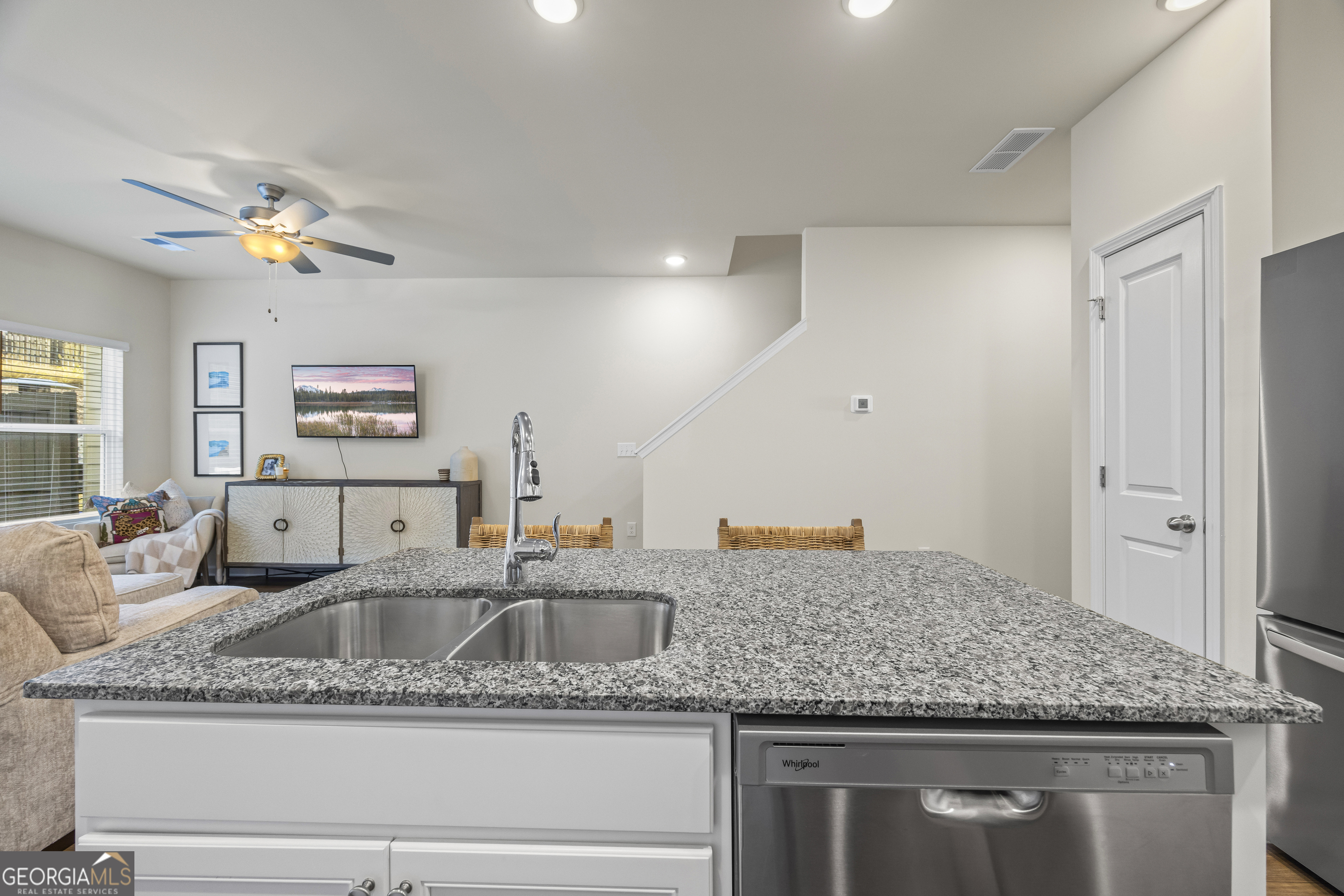 550 Buxton Road Hoschton, GA 30548 - Photo 16 of 57 a kitchen with granite countertop a sink a counter top space and living room