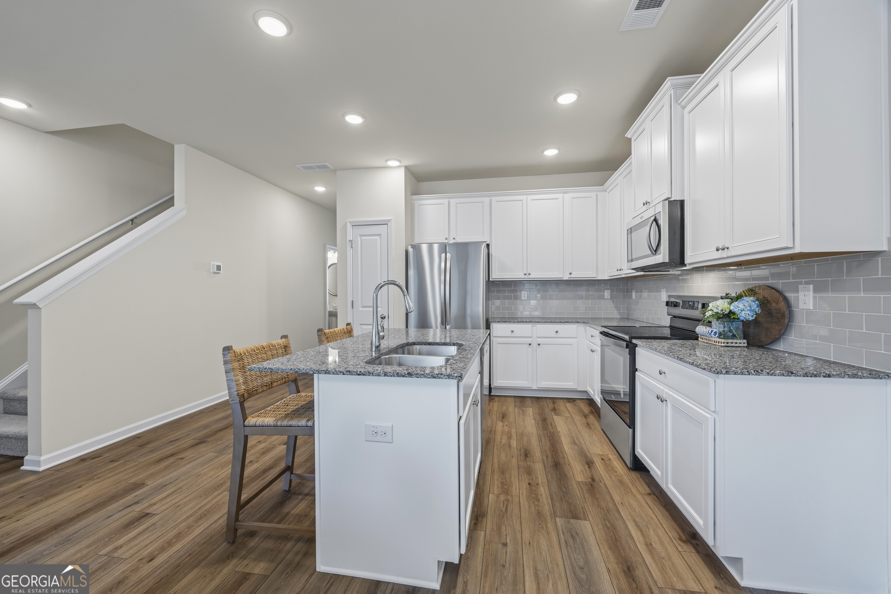 550 Buxton Road Hoschton, GA 30548 - Photo 19 of 57 a kitchen with stainless steel appliances granite countertop a sink refrigerator and cabinets
