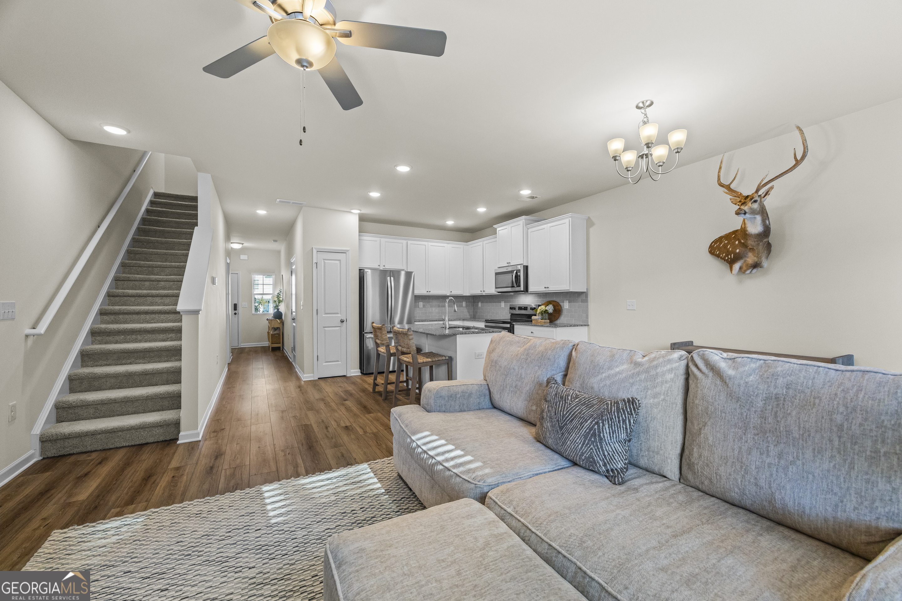 550 Buxton Road Hoschton, GA 30548 - Photo 23 of 57 a living room with furniture kitchen view and a chandelier