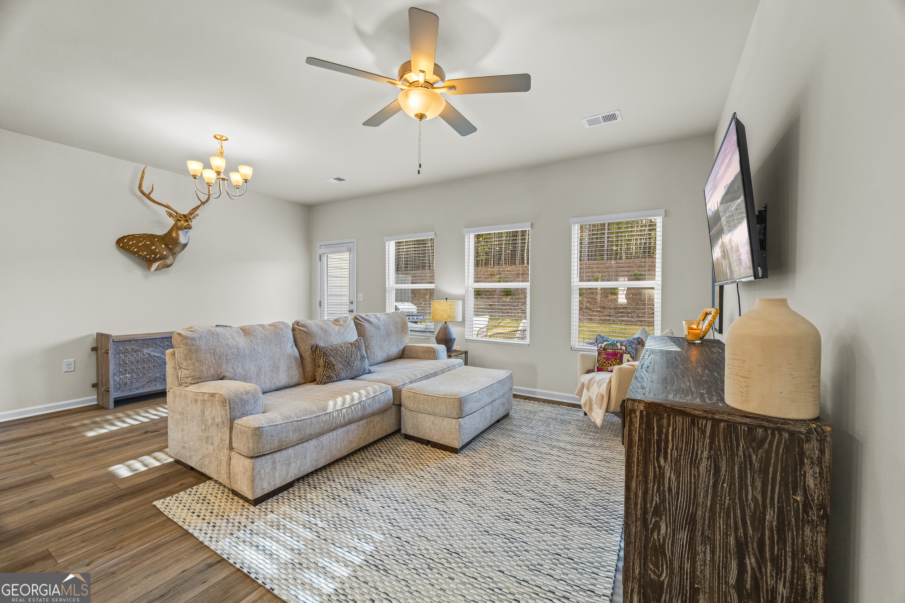 550 Buxton Road Hoschton, GA 30548 - Photo 24 of 57 a living room with furniture a chandelier and a flat screen tv