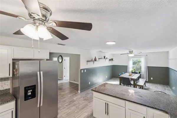 a kitchen with kitchen island a counter top space appliances and cabinets