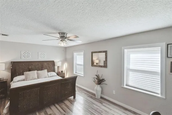 a spacious bedroom with a large bed and a chandelier