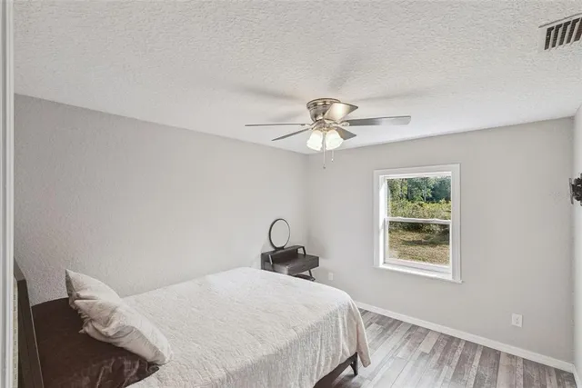 a spacious bedroom with a large bed and a chandelier