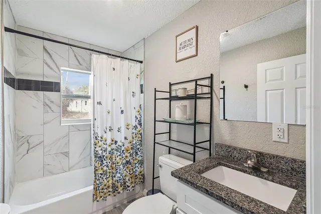 a bathroom with a granite countertop sink a shower and a mirror
