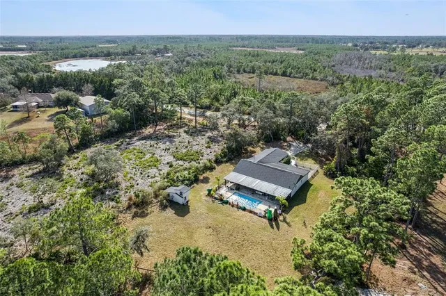an aerial view of a house with a yard and lake view