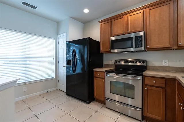 a kitchen with stainless steel appliances granite countertop a stove a refrigerator and a microwave