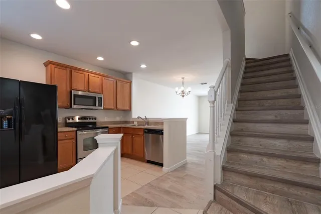 a kitchen with stainless steel appliances granite countertop a refrigerator and a stove top oven