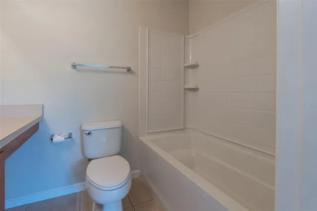 a white toilet sitting next to a bath tub