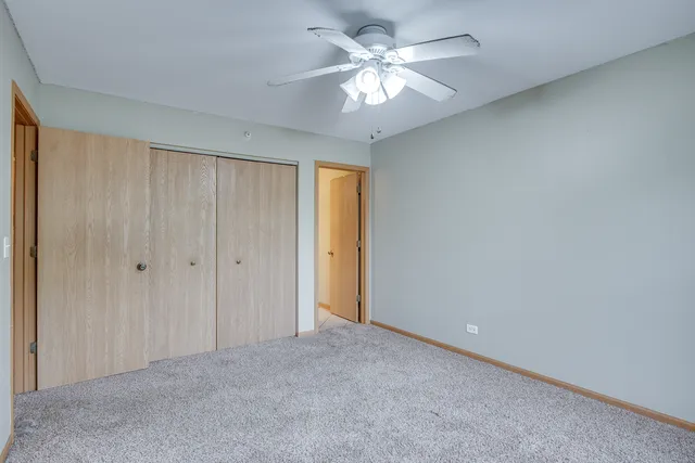 a view of an empty room and chandelier fan