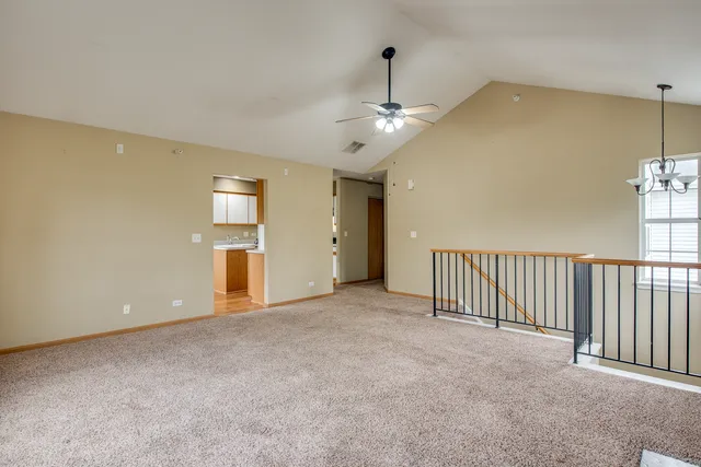 en empty room with windows and ceiling fan