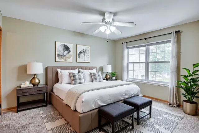 an empty room with a chandelier fan and windows