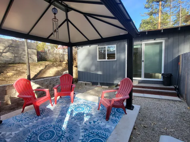 a view of a patio with table and chairs under an umbrella with a fire pit