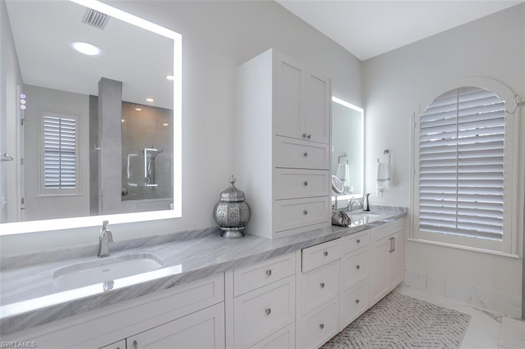 7323 Acorn Way Naples, FL 34119 - Photo 13 of 21 Bathroom with double vanity, lighted mirrors, a walk in double shower, and light tile flooring