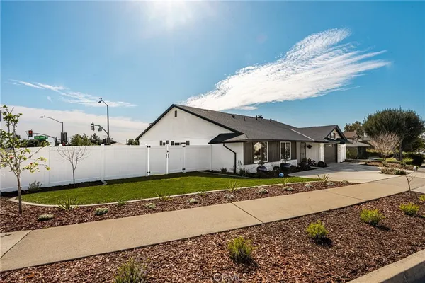 a view of a house with a yard and large tree in front of it
