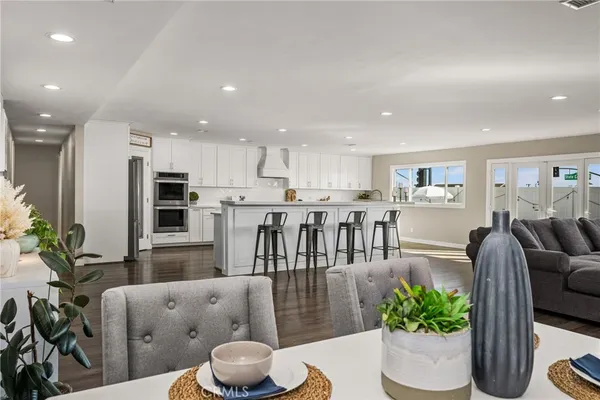 a living room with furniture kitchen and a wooden floor