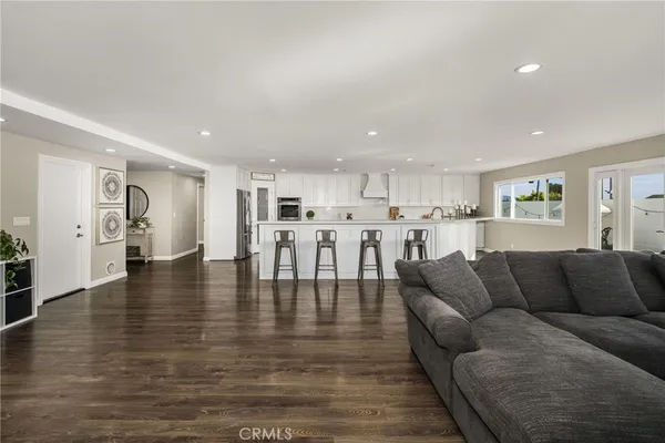 a living room with furniture and a view of kitchen