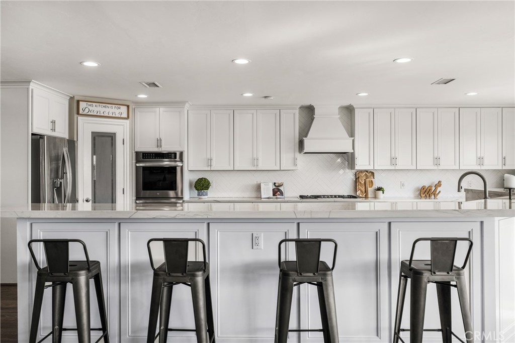 688 Buttonwood Drive Brea, CA 92821 - Photo 21 of 54 a kitchen with stainless steel appliances granite countertop a table chairs refrigerator and sink