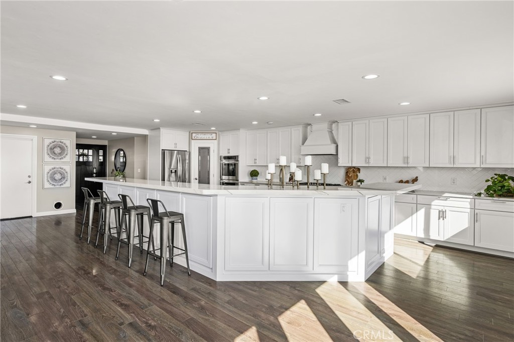 688 Buttonwood Drive Brea, CA 92821 - Photo 24 of 54 a kitchen with stainless steel appliances granite countertop a refrigerator a stove top oven and a dining table with wooden floor