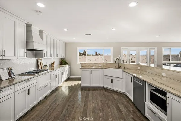 a large kitchen with white cabinets and stainless steel appliances