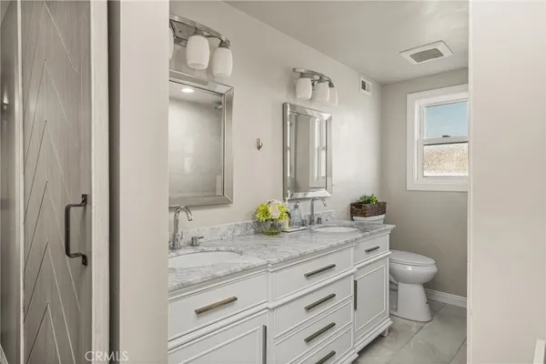 a bathroom with a granite countertop sink a toilet and a mirror