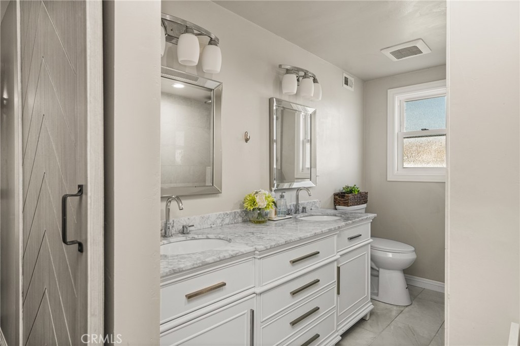 688 Buttonwood Drive Brea, CA 92821 - Photo 31 of 54 a bathroom with a granite countertop sink toilet and mirror