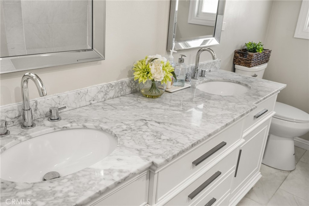 688 Buttonwood Drive Brea, CA 92821 - Photo 32 of 54 a bathroom with a granite countertop sink a toilet and a mirror