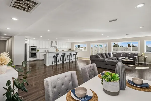 a living room with furniture kitchen and a table