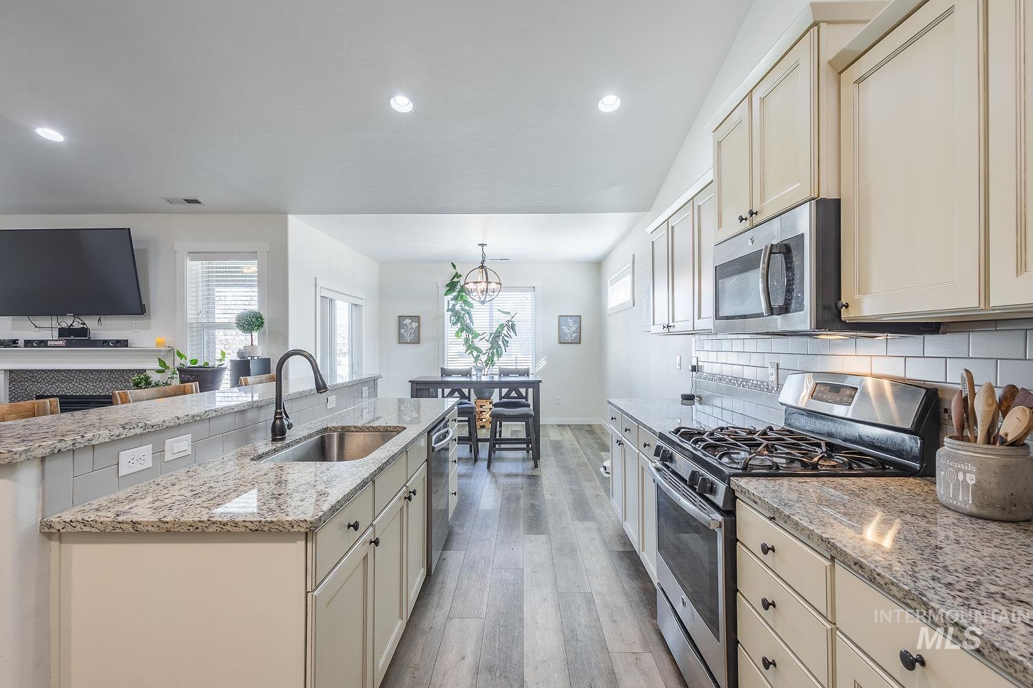 1332 West Raelin Drive Nampa, ID 83686 - Photo 15 of 48 Kitchen featuring cream cabinets, stainless steel appliances, and light stone countertops