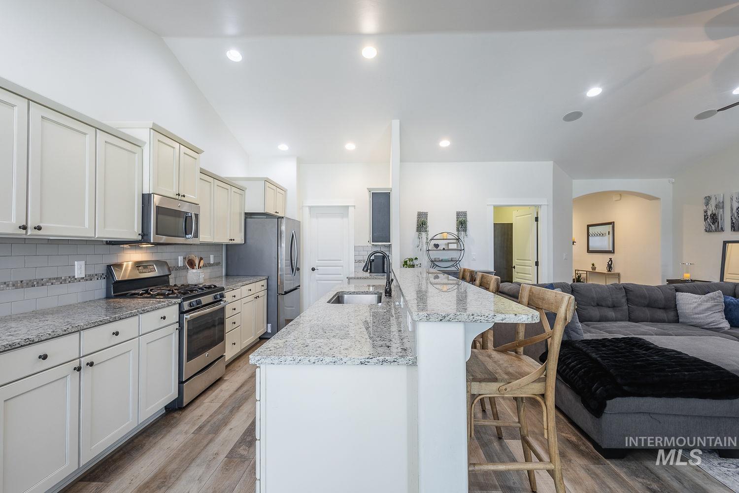 1332 West Raelin Drive Nampa, ID 83686 - Photo 48 of 48 Kitchen with open floor plan, stainless steel appliances, a breakfast bar area, light stone counters, and tasteful backsplash