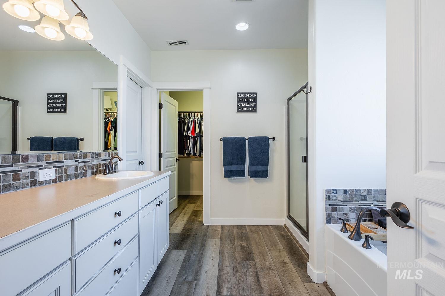 1332 West Raelin Drive Nampa, ID 83686 - Photo 26 of 48 Bathroom with decorative backsplash, vanity, a stall shower, a bath, and recessed lighting