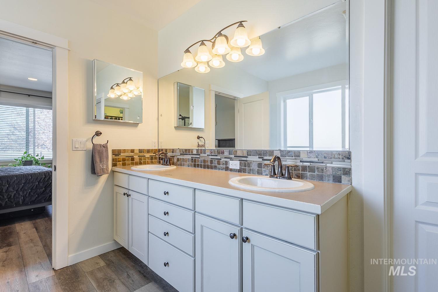 1332 West Raelin Drive Nampa, ID 83686 - Photo 28 of 48 Ensuite bathroom with backsplash, double vanity, and dark wood finished floors
