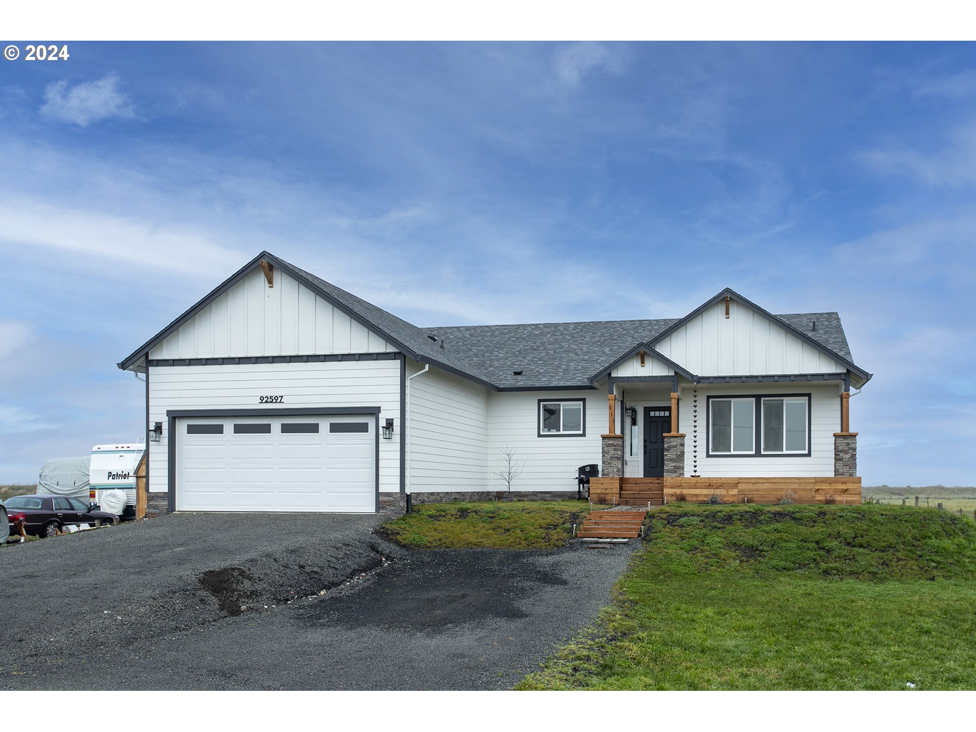a view of a house with a yard and large tree