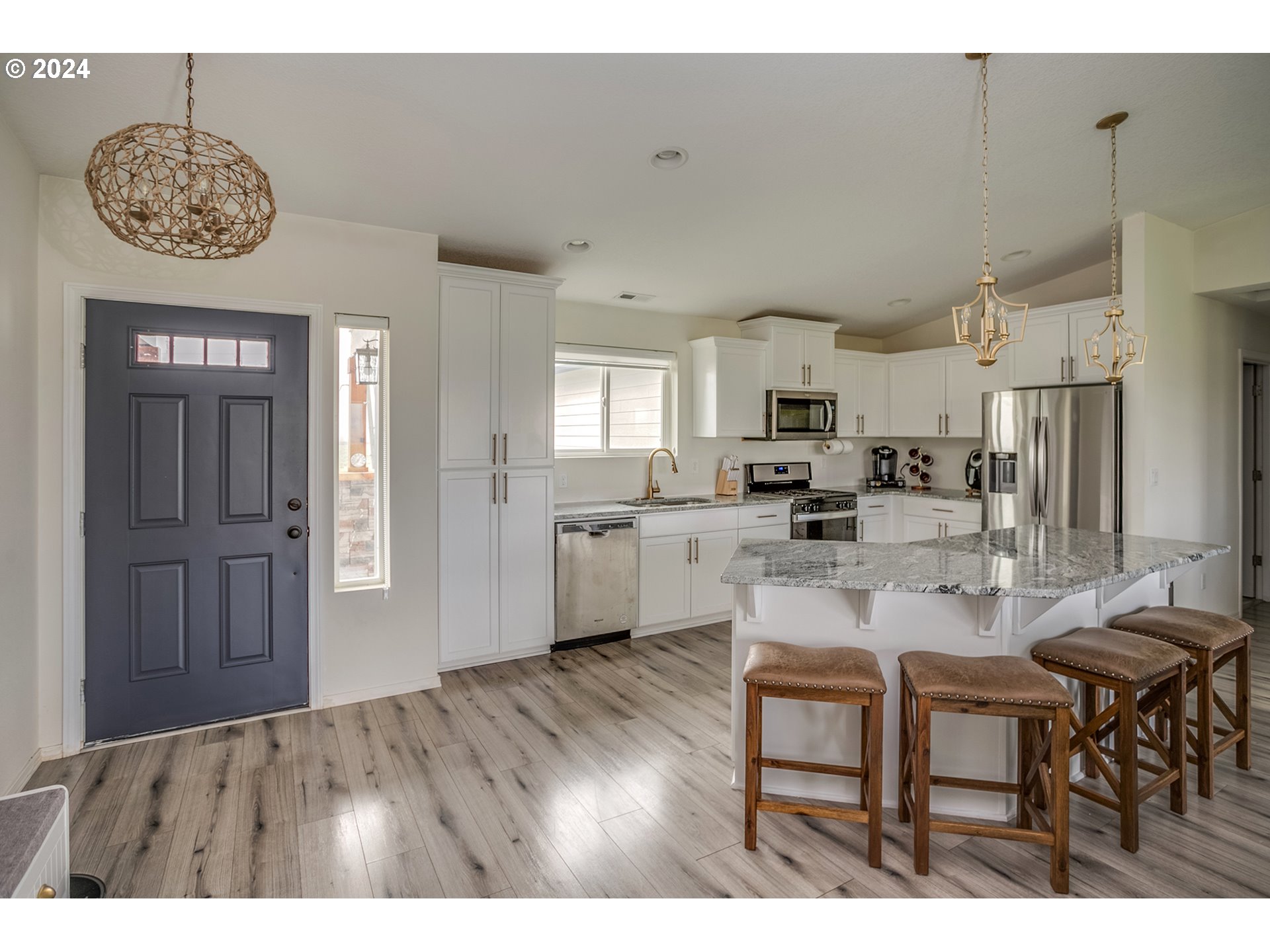 92597 Wireless Road Astoria, OR 97103 - Photo 6 of 35 a kitchen with stainless steel appliances granite countertop a refrigerator a stove a sink a dining table and chairs with wooden floor