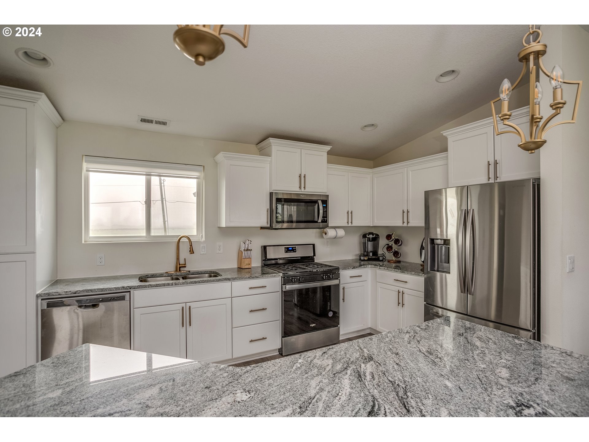 92597 Wireless Road Astoria, OR 97103 - Photo 8 of 35 a kitchen with stainless steel appliances a sink a stove a refrigerator cabinets and a window