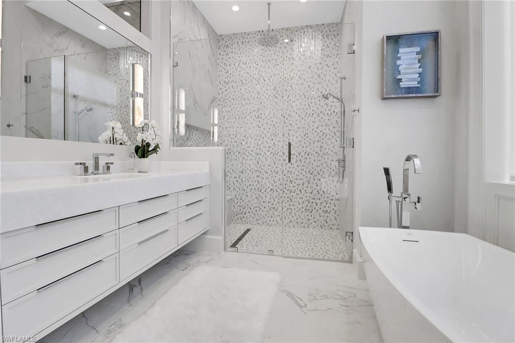 636 Portside Drive Naples, FL 34103 - Photo 14 of 50 a bathroom with a tub sink shower and mirror