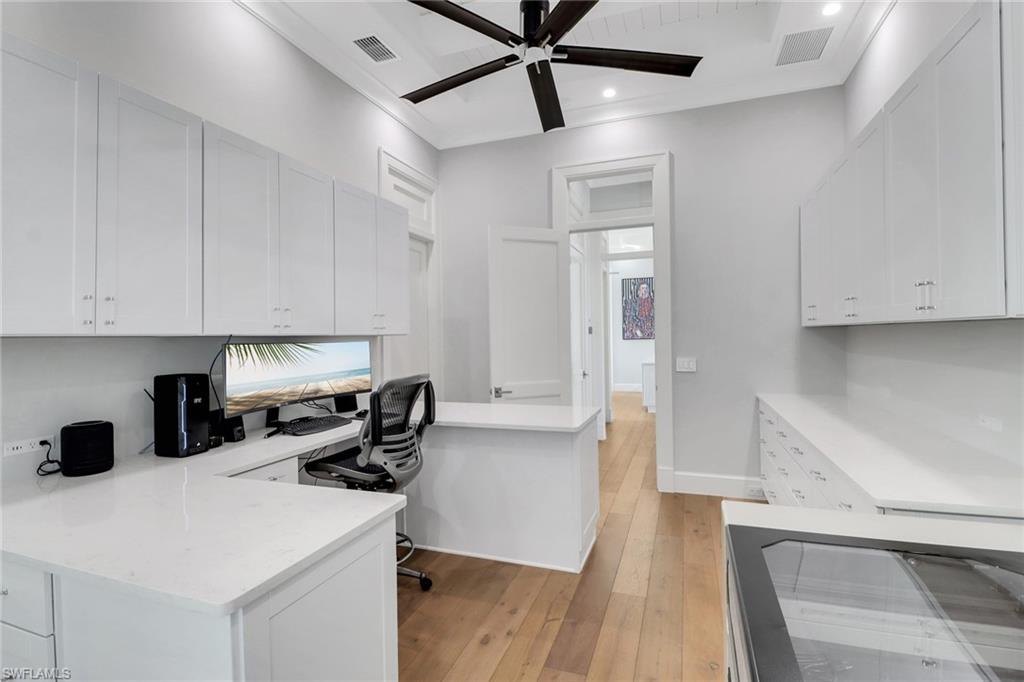 636 Portside Drive Naples, FL 34103 - Photo 20 of 50 a kitchen that has a lot of cabinets a sink and wooden floor
