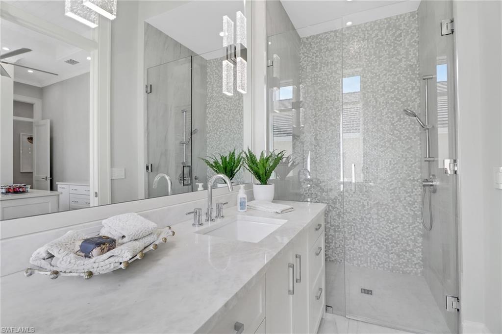 636 Portside Drive Naples, FL 34103 - Photo 24 of 50 a bathroom with a double vanity sink and shower