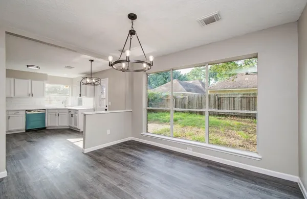 a view of a large kitchen with a large window cabinets and stainless steel appliances