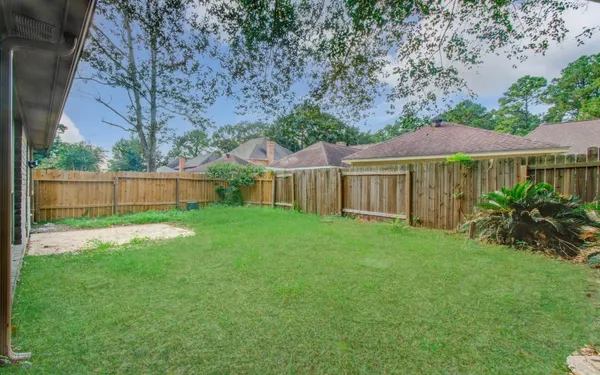 a view of a house with backyard and a tree