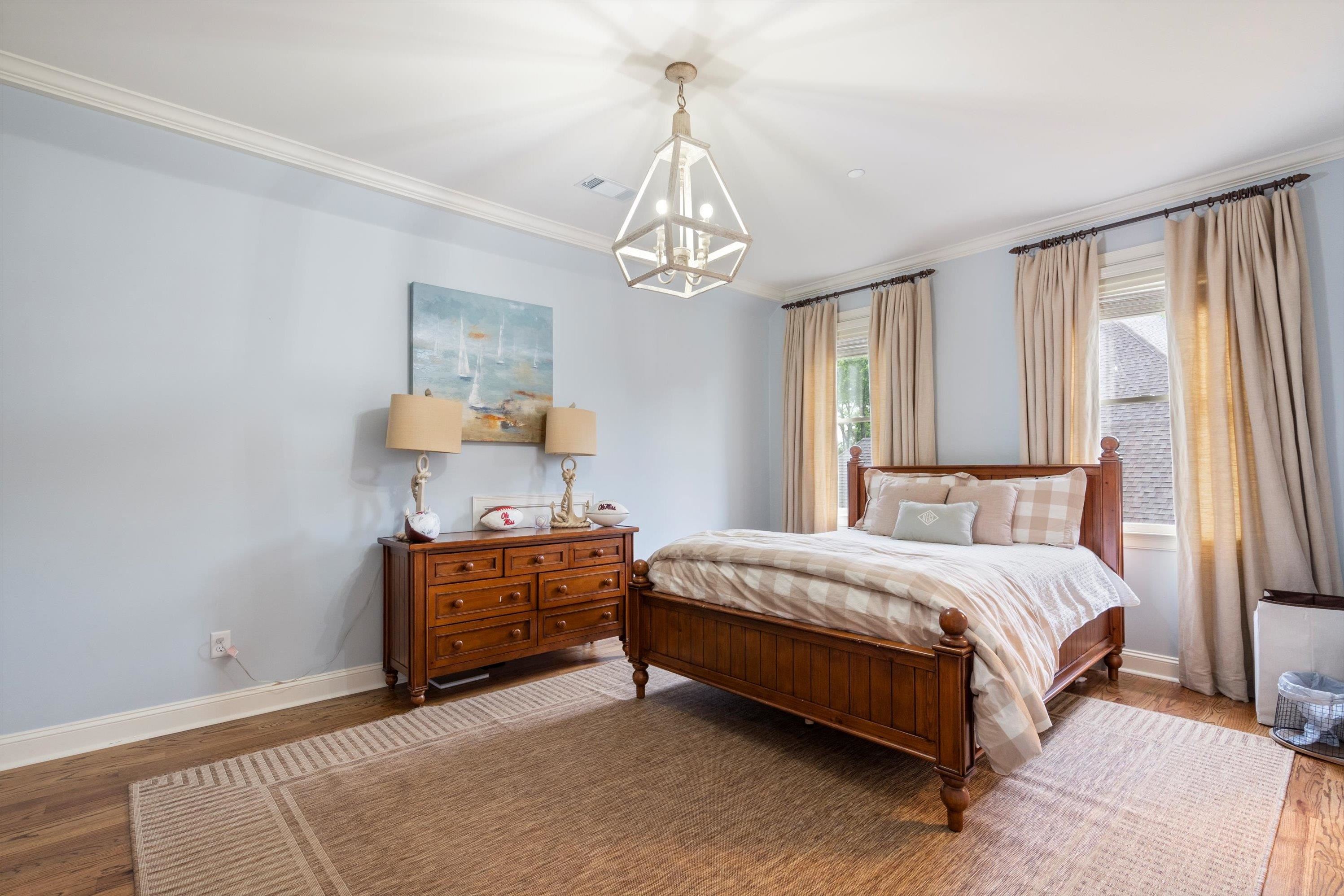 4621 Spring Meadow Way North Olive Branch, MS 38654 - Photo 27 of 40 a spacious bedroom with a bed and a chandelier
