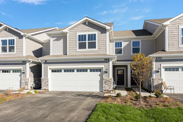 a front view of a house with a yard and garage