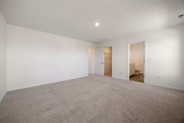 a view of an empty room with closet and a window
