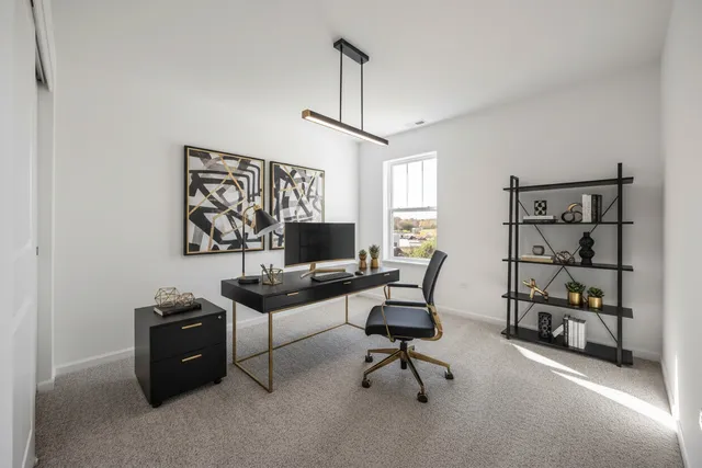 a view of a workspace with furniture and a window